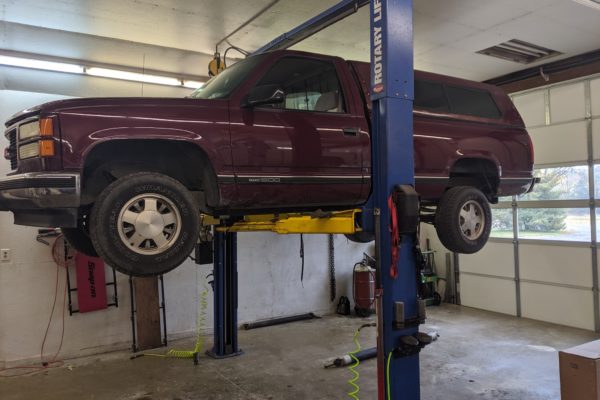 Large SUV GMC elevated for shop maintenance