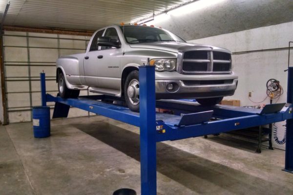 Silver Doge RAM 1500 with cab lights elevated for shop maintenance
