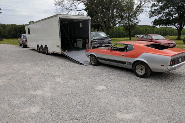 classic sports car getting loaded into a trailer for transportation