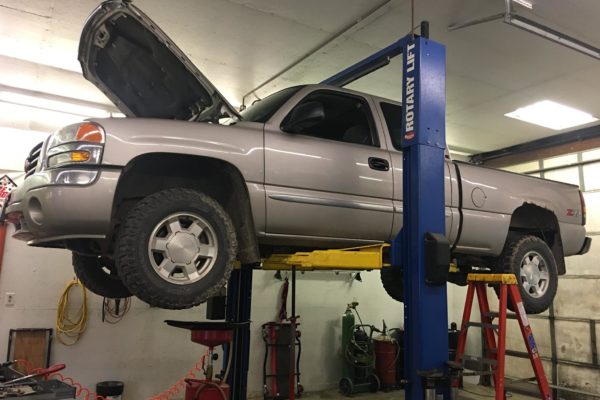 Grey Chevy Z71 truck elevated for shop maintenance