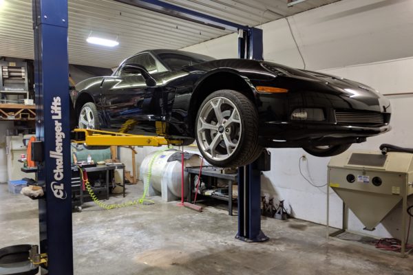 Black sports car elevated | shop maintenance